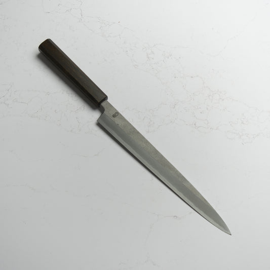 Sakai Kikumori Kikuzuki Rin Yanagiba 270mm – Hand-forged carbon steel yanagiba knife with ebony handle, crafted in Sakai, Japan. Available at Blade & Board.